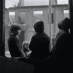 Black and white photograph of children in a demolished street in Hull.