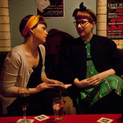 Colour photograph of two girls in a bar wearing turbans