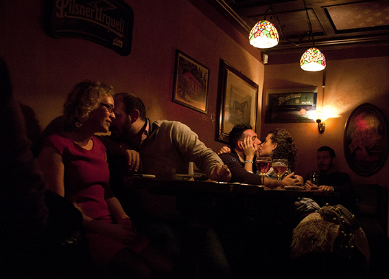 Photograph of a couple kissing in a bar.