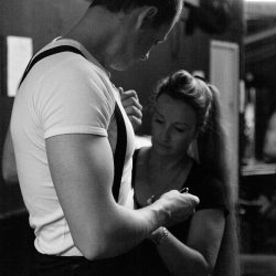 Black and white photograph of Michael Togni of the Togni Brothers, his mother is helping him get ready.