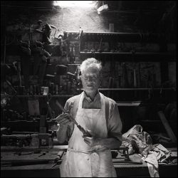 Black and white photograph of a coffin maker in his workshop.