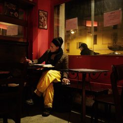 Photograph of a girl in a bar in Milan in yellow trousers.