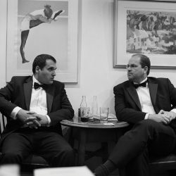 Black and white photograph of two men in Evening Dress in a café.