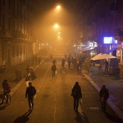 Colour photograph of people going home in the mist in Milan.