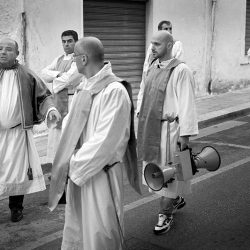 Black an white photograph of priests, one with a megaphone in Southern Italy.