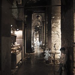 Infrared photograph of a girls waiting under a portico for someone.