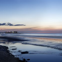 Colour photograph of Cromer beach in the evening May light.