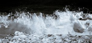 Close up toned photograph of waves crashing ashore in Cromer.