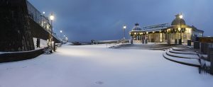 A colour photograph of footprints in the snow near Cromer pier.