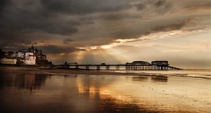 Panoramic photograph of a pink house and Cromer pier