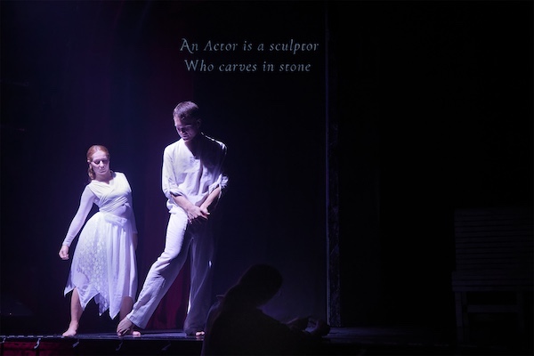 A dancer traces his toe slowly on the stage, a young women follows him intently, The title makes sense of it all.
