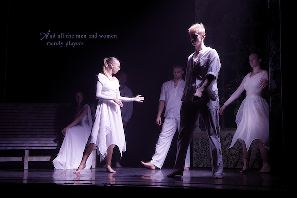 Actors in white strut on to the stage. The Quote from Shakespeare makes sense of it all.